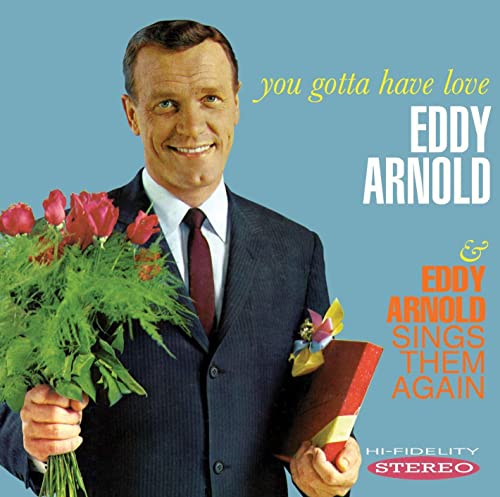 Eddy Arnold in a suit holding a bouquet of red roses and a gift.