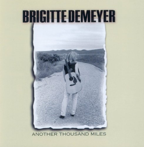 CD cover: Brigitte DeMeyer, woman with guitar on a rural road.