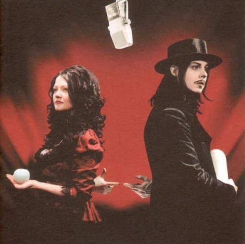 The White Stripes duo in black and red, holding white objects.