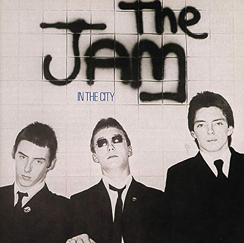 Album cover for The Jam’s “In The City” featuring three men in suits.
