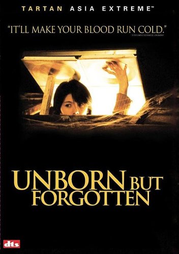 Woman peeking out from under a hatch with a frightened expression at night.