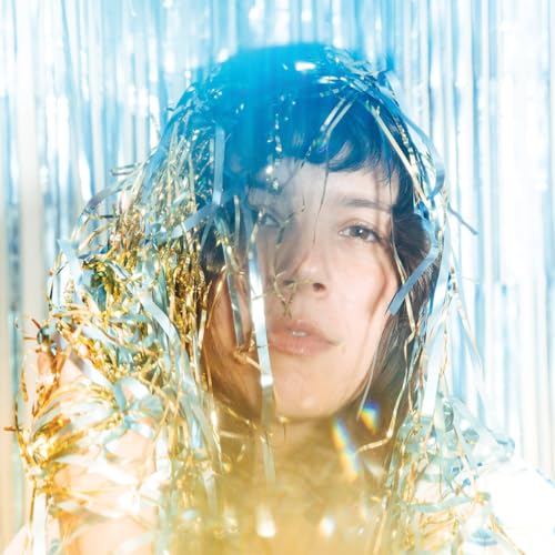 Person with bangs partially obscured by shimmering metallic streamers.