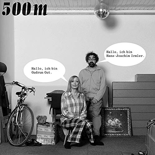 Black and white album cover featuring two people and a bicycle in a room.