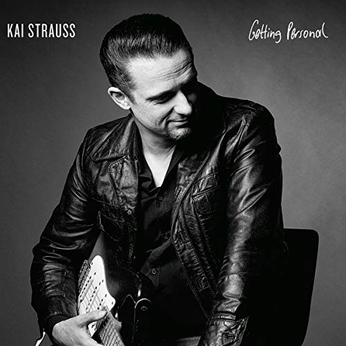Black and white portrait of Kai Strauss with a guitar, album cover.