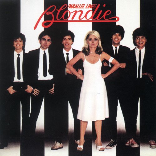Blondie band members standing in front of a black and white striped background.