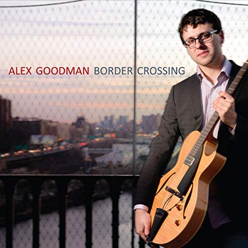 Alex Goodman holding a guitar, city skyline visible through window mesh.
