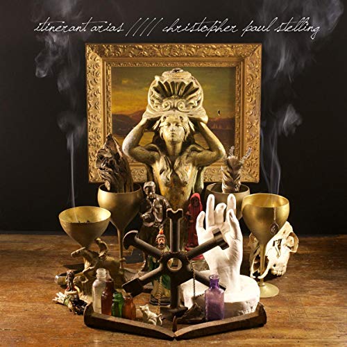 Album cover for "Itinerant Arias" with a statue, skull, and ornate frame.