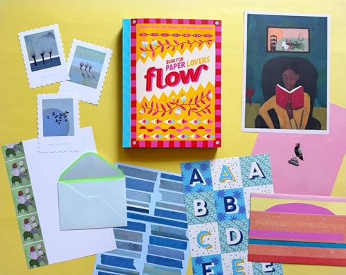 Colorful book with floral cover surrounded by stationery and art prints.