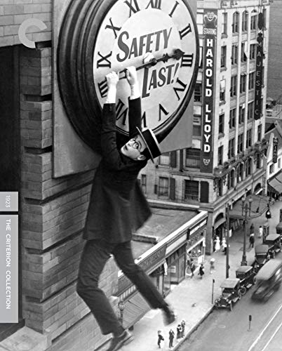 Harold Lloyd hanging from a giant clock face above a busy city street.