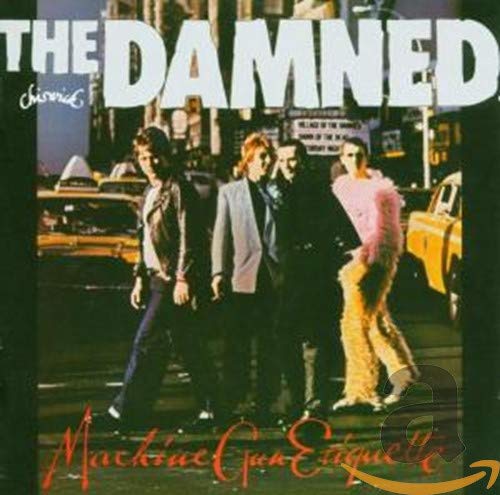 The Damned band members walking across a street with yellow taxis in the background.