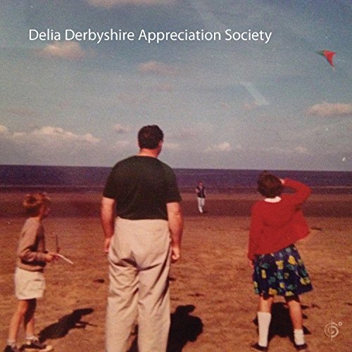 CD cover: people on a beach looking at a kite in a blue sky.