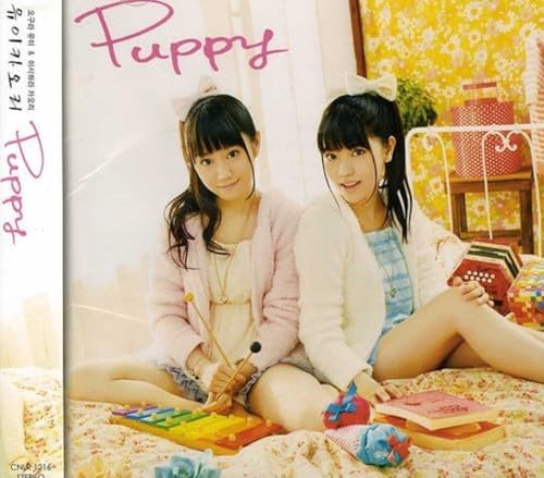 CD cover featuring two young women with puppy ears, lying on a bed.