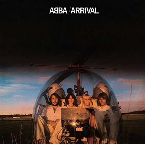 The four members of ABBA sit inside a helicopter against a sunset sky.