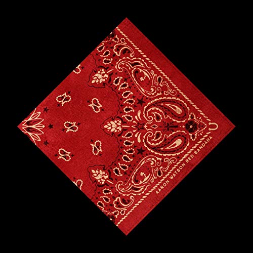 Red bandana with white paisley design, tilted on black background.