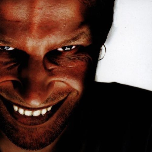 Close-up of a man's face with a wide, intense, shadowed grin.