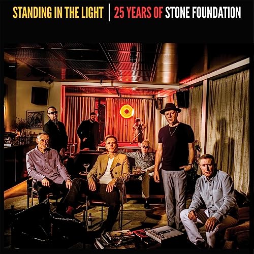 Stone Foundation band members in a dimly lit room, album cover.
