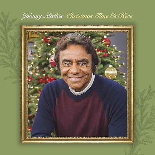 Johnny Mathis portrait in front of a decorated Christmas tree.