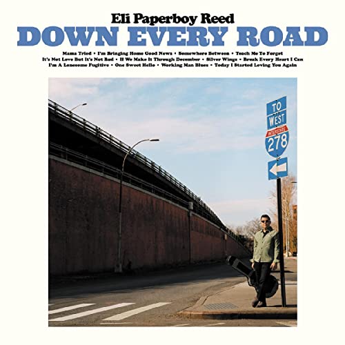 Album cover: man with guitar stands by a highway sign.