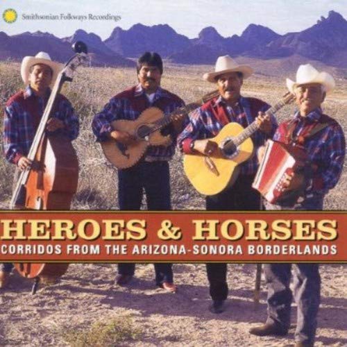 Four musicians with stringed instruments in a desert landscape.