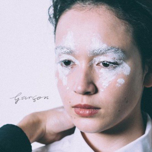Close-up portrait of a person with white paint on their face.