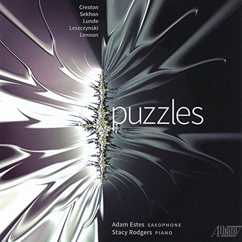CD cover for "Puzzles" with abstract silver and green design.