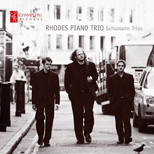 Black and white photo of three musicians walking on a city street.