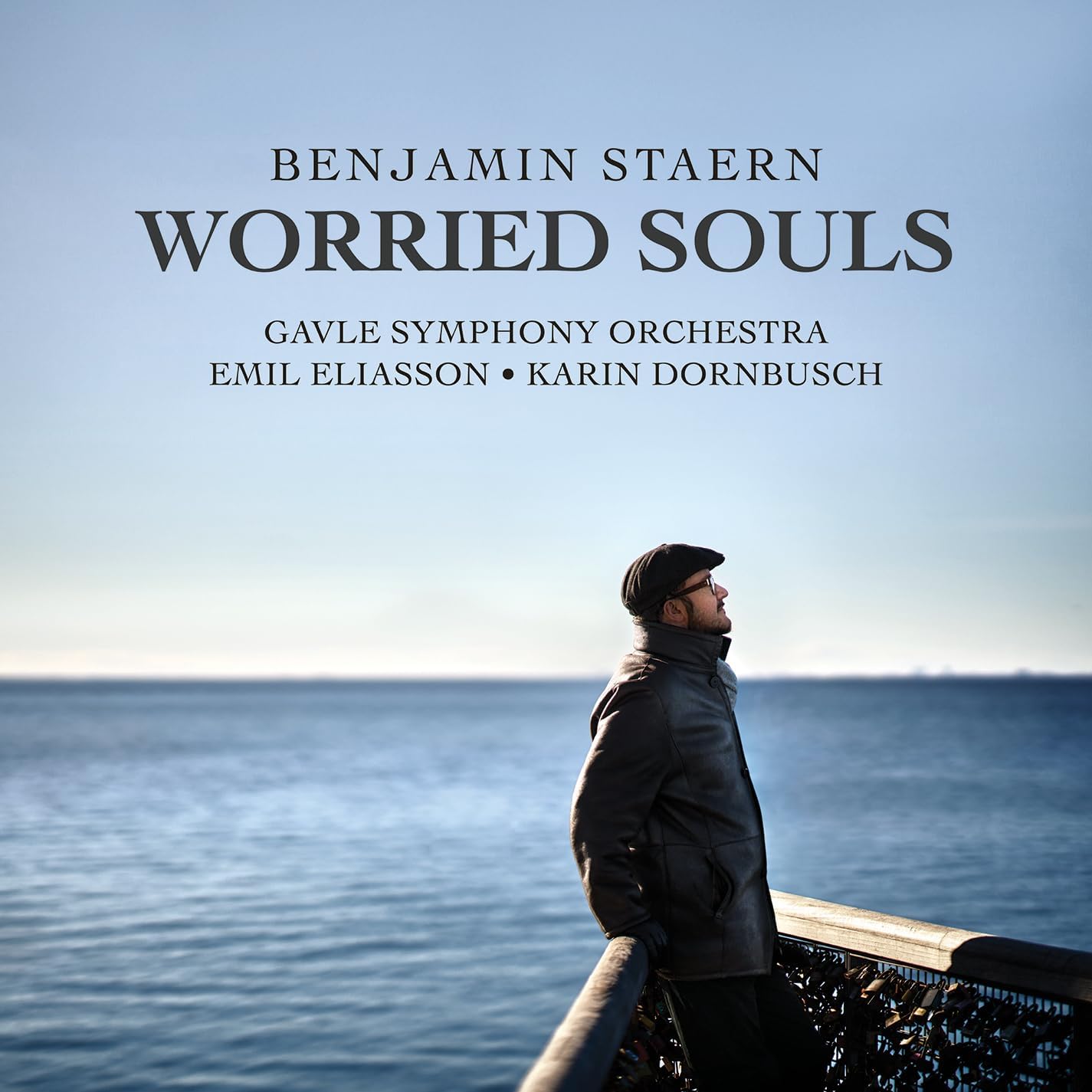 CD cover: Man in cap looking at a calm, blue sea.