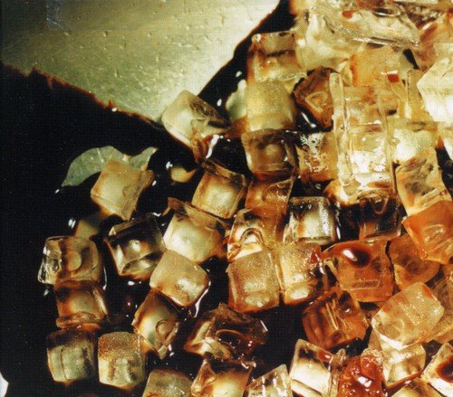 Close-up of dark liquid and ice cubes, album cover art.