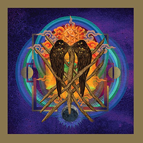 Album cover art featuring two dark, multi-eyed wings over wooden sticks and geometric patterns.