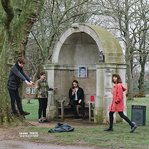 Album cover: four people near a stone structure in a park.