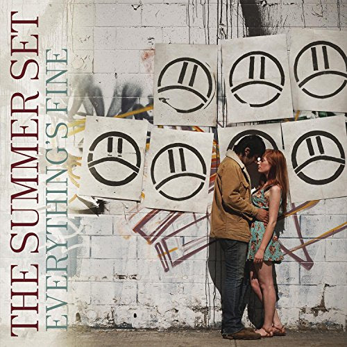 CD cover: couple embracing before graffiti-covered brick wall with symbols.