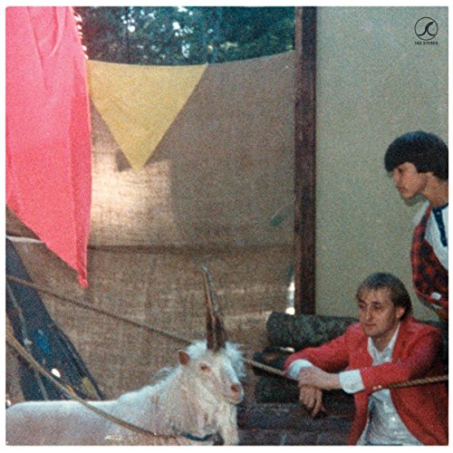 CD cover: man, goat with horn, flags, and a wooden structure.