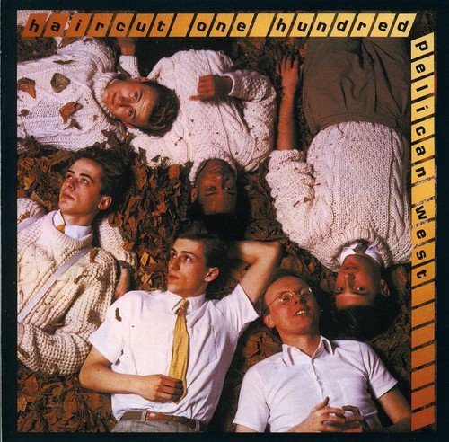 Five men in white shirts and sweaters lying on autumn leaves, album cover art.