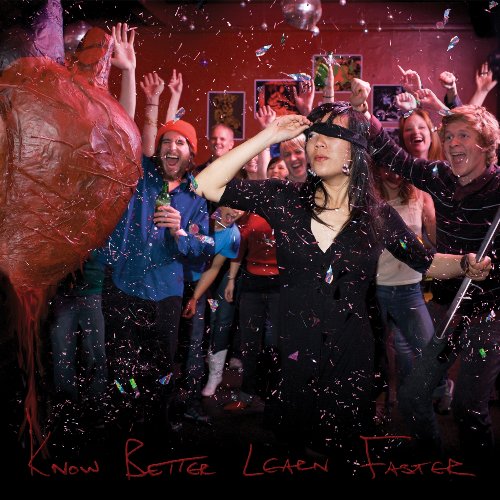 CD cover: group celebrating with confetti, a large brain sculpture visible.