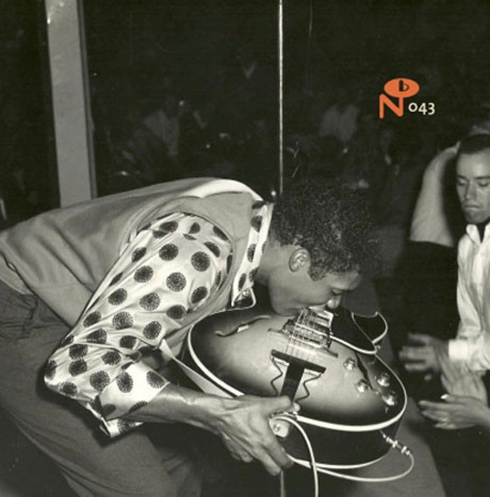 Black and white photo of a guitarist playing, album cover art.