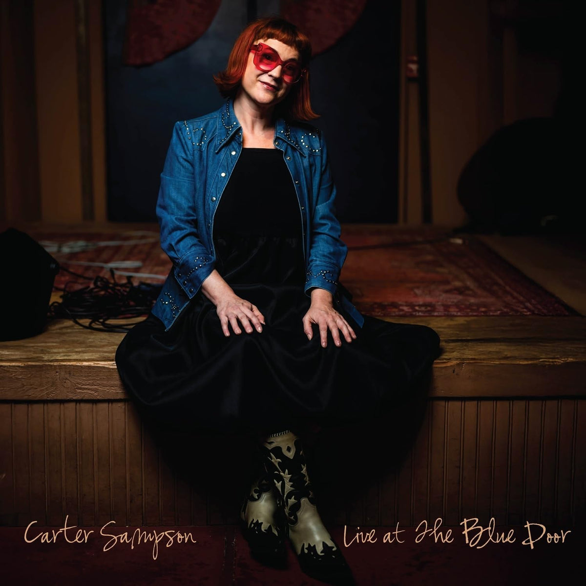 Carter Sampson album cover: woman with red glasses sitting on wood.