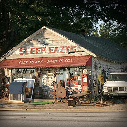 Run-down building with "Sleep Eazys" sign and vintage items outside.