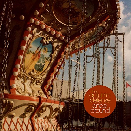 Vintage carousel swing ride with ornate details and a blue sky.