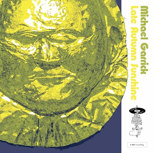 Yellow abstract face on vinyl record cover, with text and small spaceship.