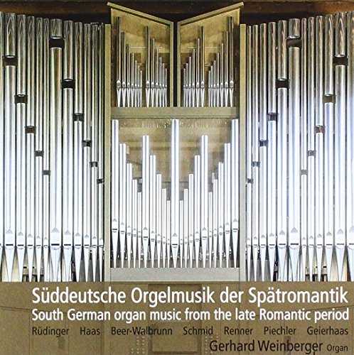 Close-up of a large pipe organ, silver-colored, with German text below.