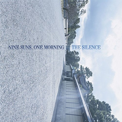 CD cover with a textured road leading to traditional buildings under a blue sky.