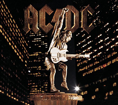 Bronze statue of a guitarist on a pedestal against a dark city skyline background.