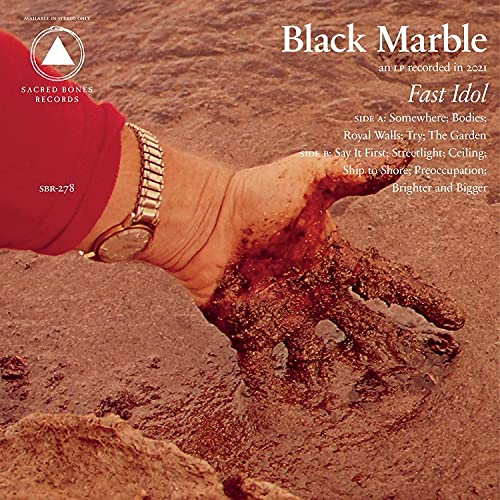 Album cover for Black Marble’s “Fast Idol” featuring a hand in sand.
