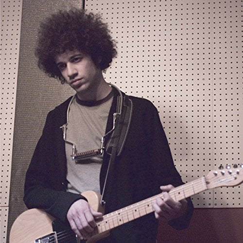 Ron Franklin with curly hair holding an electric guitar.