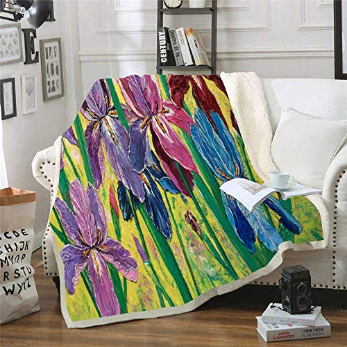 Colorful floral blanket draped over a white armchair with books and a mug.