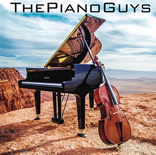Piano and cello on a cliff overlooking a desert landscape.