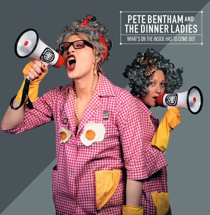 Two women in checkered dresses with hair curlers shout into megaphones.