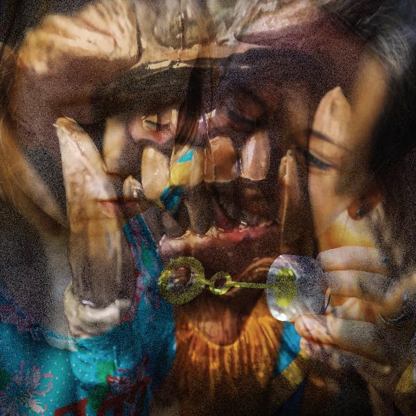 Distorted, layered portrait with a small, glowing green and clear object.