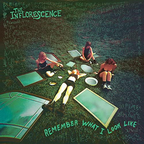 Album cover: three people lying and sitting on green grass.
