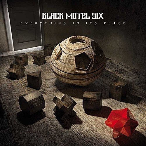 CD cover with wooden geometric shapes and a red crystal.